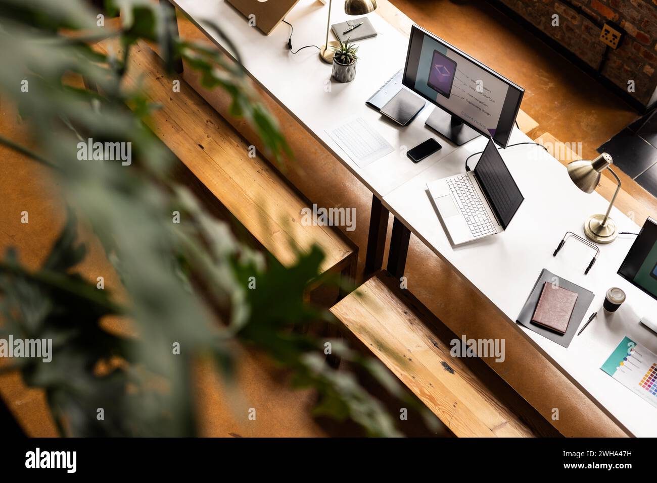 Un moderno e informale ufficio d'affari dispone di una scrivania pulita con gadget tecnologici Foto Stock