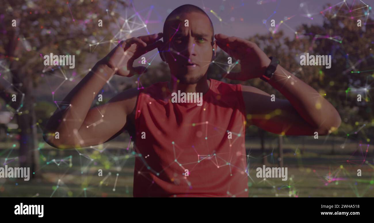 Uomo birazziale che indossa le cuffie all'aperto Foto Stock