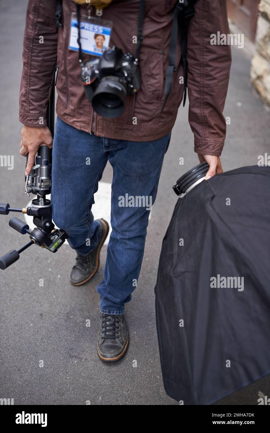 Illuminazione, attrezzature e fotografi in esterni per scattare foto con obiettivo e attrezzatura della fotocamera. Cameraman, camminata e strumenti fotografici per stampa, progetto Foto Stock