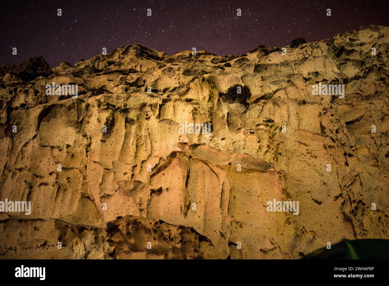 Una scena notturna surreale si dispiega con strane forme su una montagna rocciosa cancerosa, abbracciata dalla bellezza cosmica della via Lattea in una meraviglia celeste. Foto Stock