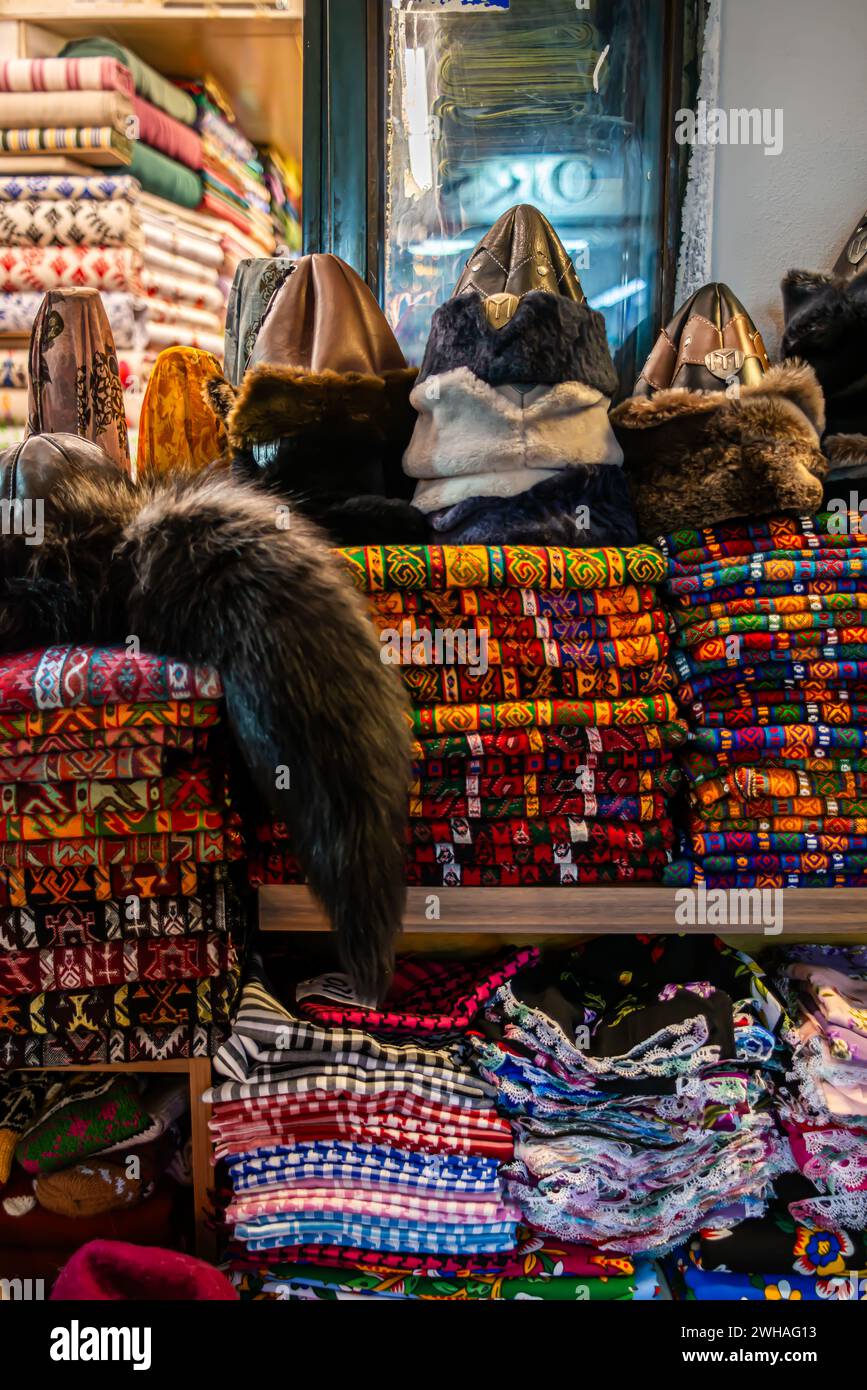 Cappello e abiti tradizionali turchi nel bazar, una vivace esposizione di tessuti, motivi e indumenti culturali, creando un mercato di diverse t Foto Stock