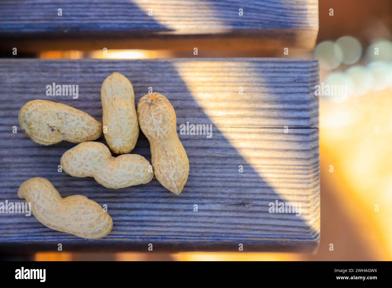 Un mucchio di arachidi disposte su una panchina rustica in legno Foto Stock