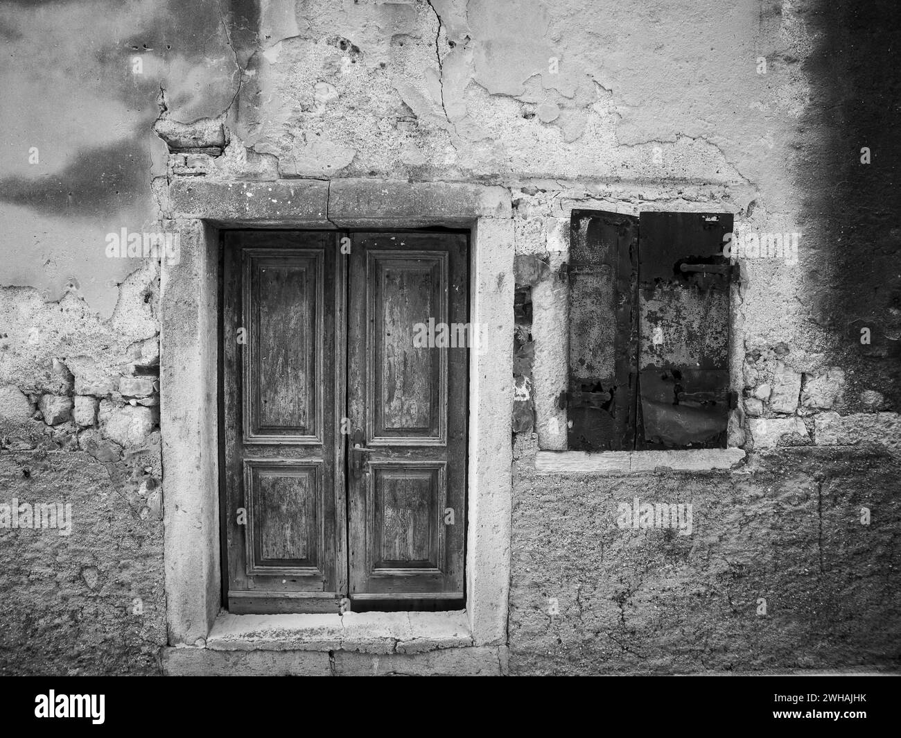 Porta e finestra molto vecchie fatte di legno, vecchia casa (isola di Cres, Croazia), bianco e nero Foto Stock