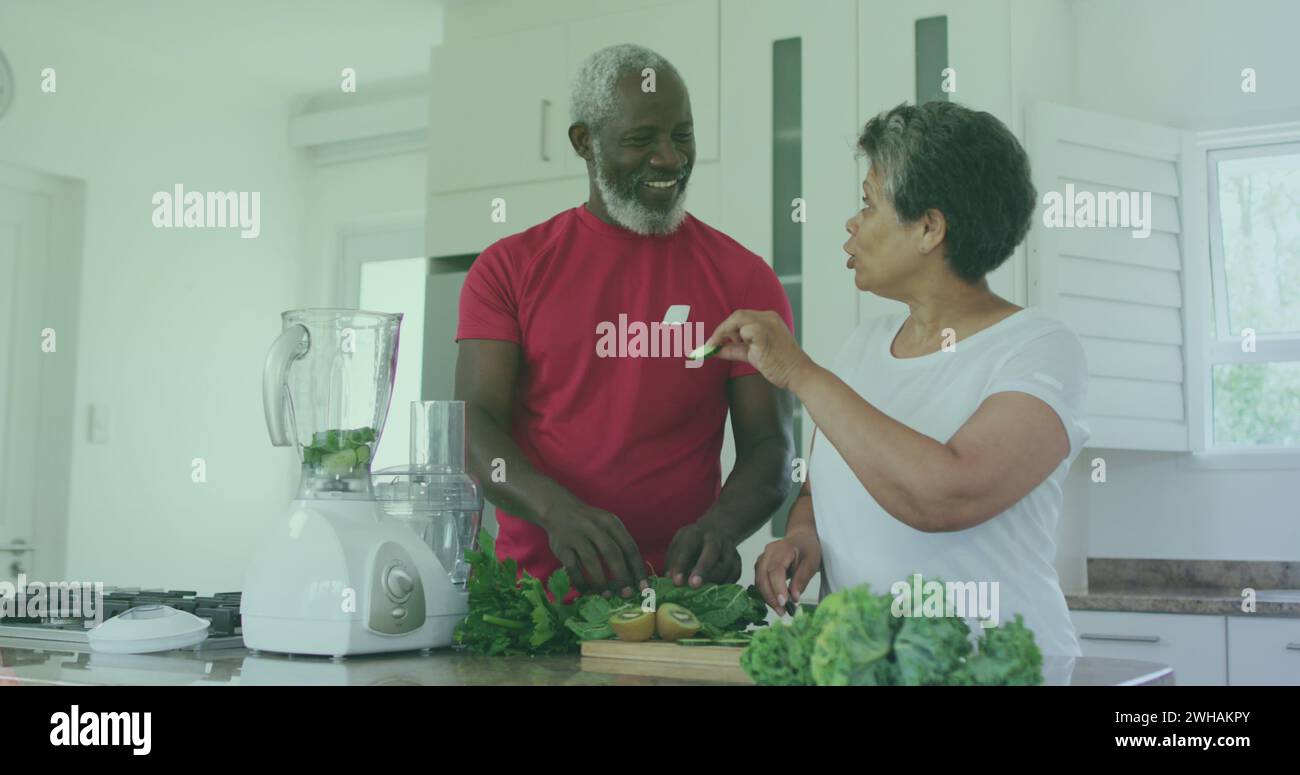 Immagine di testi di super cibi biologici sulla cucina di coppia afroamericana senior Foto Stock