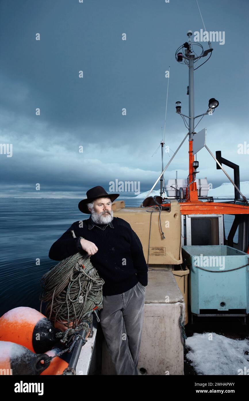 Un pescatore sulla sua barca in mare Foto Stock