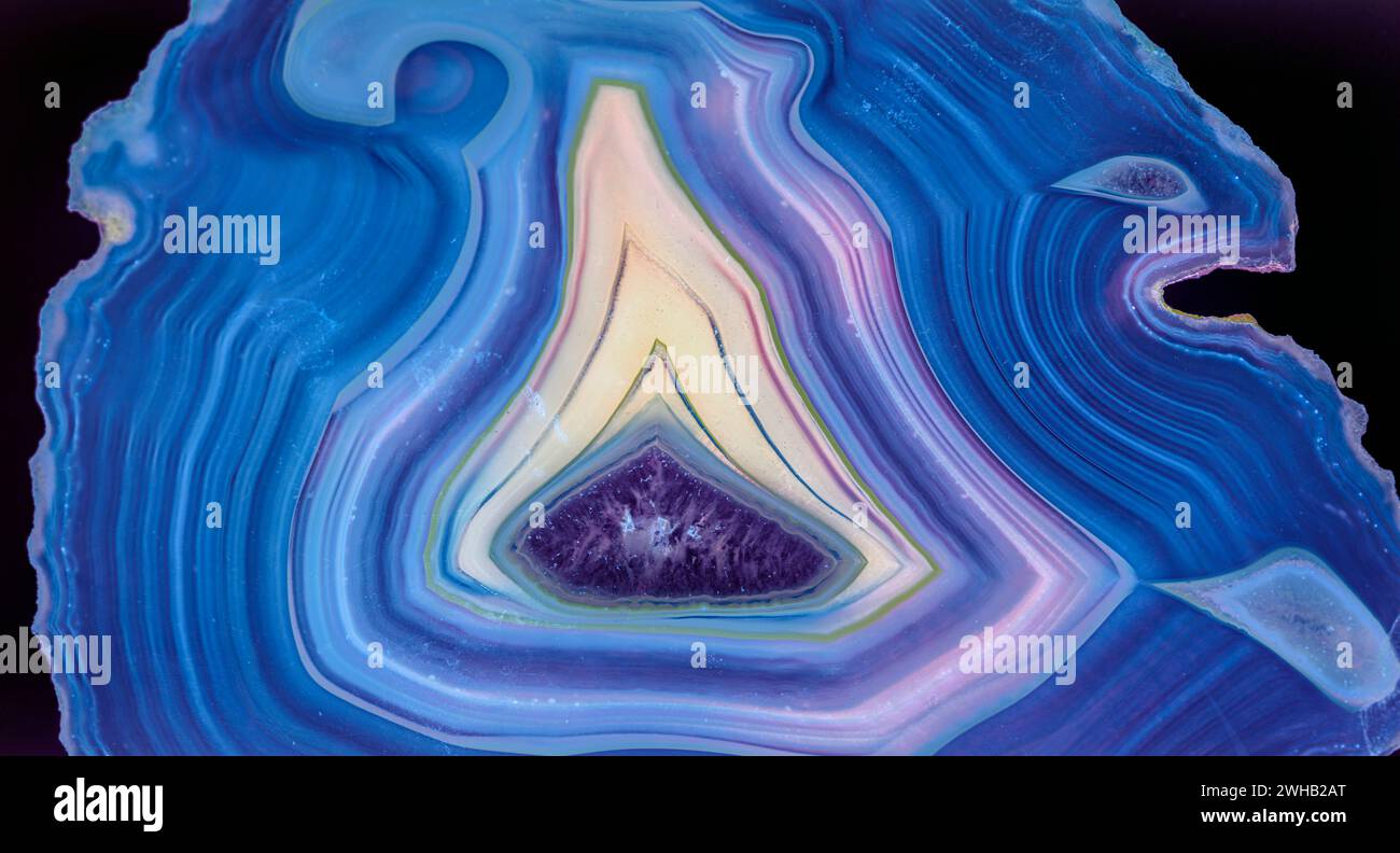 Sottile fetta di agata blu retroilluminata con cristalli in un geode, illuminata da dietro Foto Stock