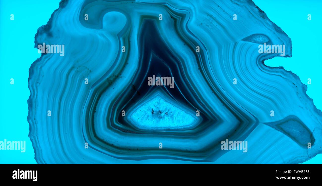 Sottile fetta di agata blu retroilluminata con cristalli in un geode, illuminata da dietro Foto Stock