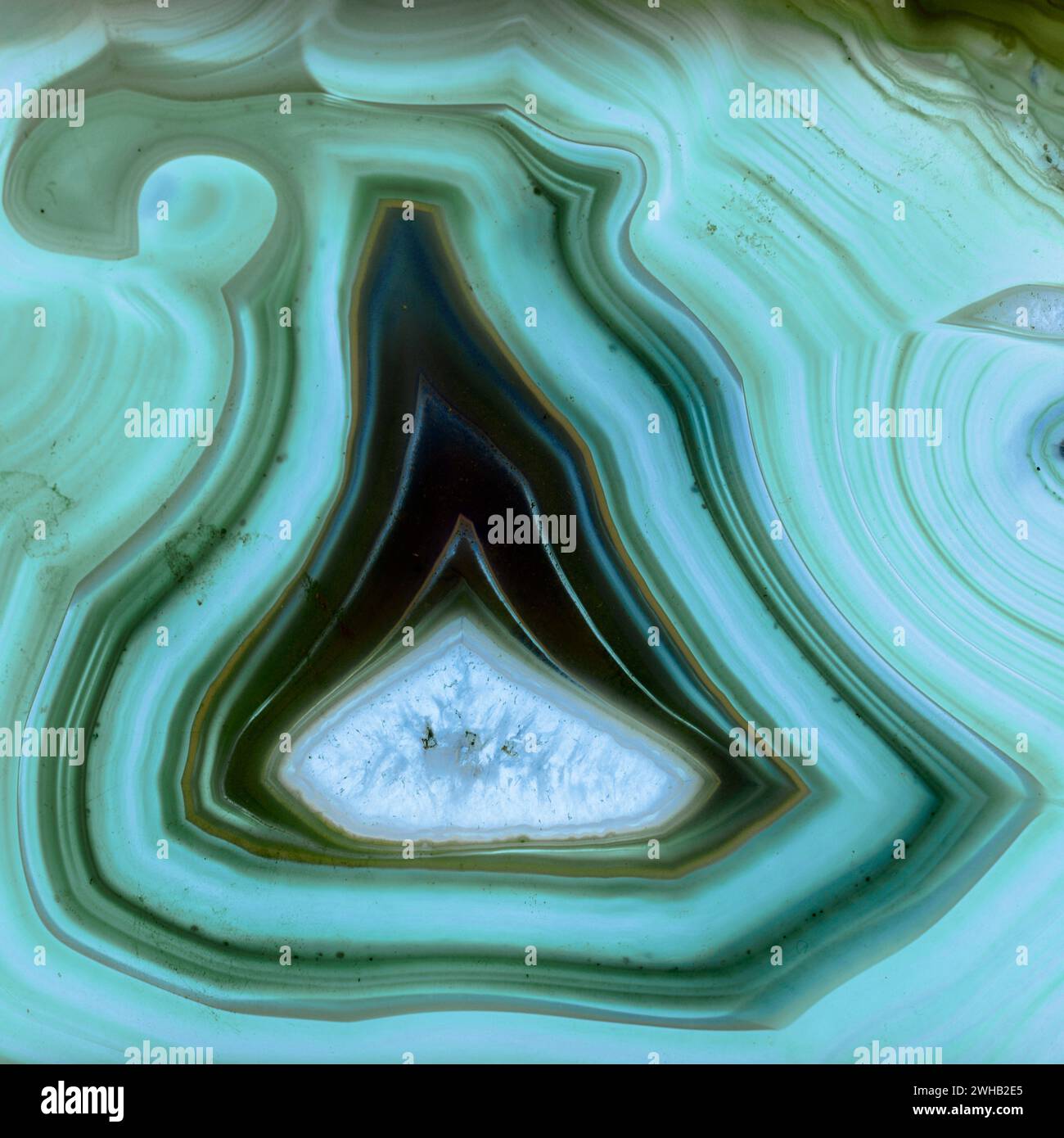 Sottile fetta di agata blu retroilluminata con cristalli in un geode, illuminata da dietro Foto Stock