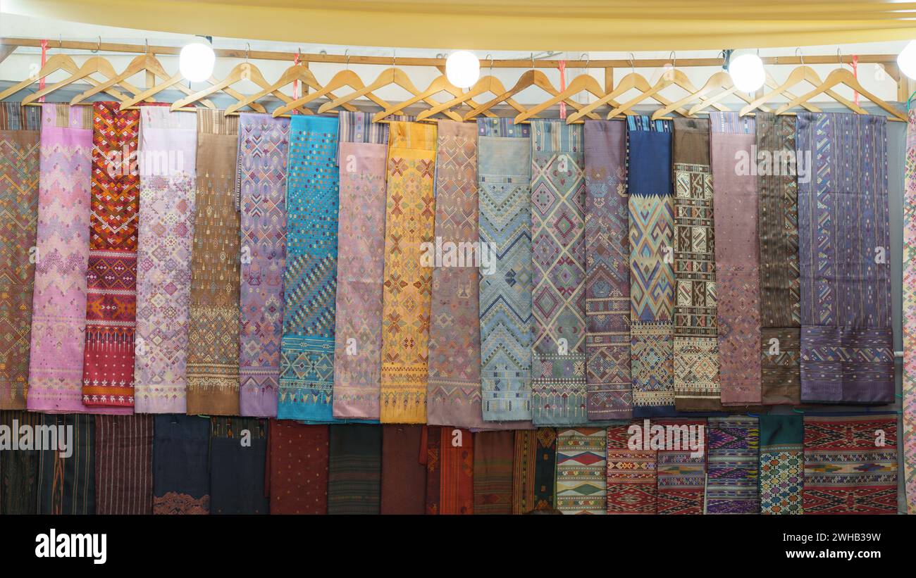 Tessuti tradizionali colorati con motivi intricati appesi in mostra in un mercato, che mostrano la bellezza culturale della lavorazione dei tessuti Foto Stock