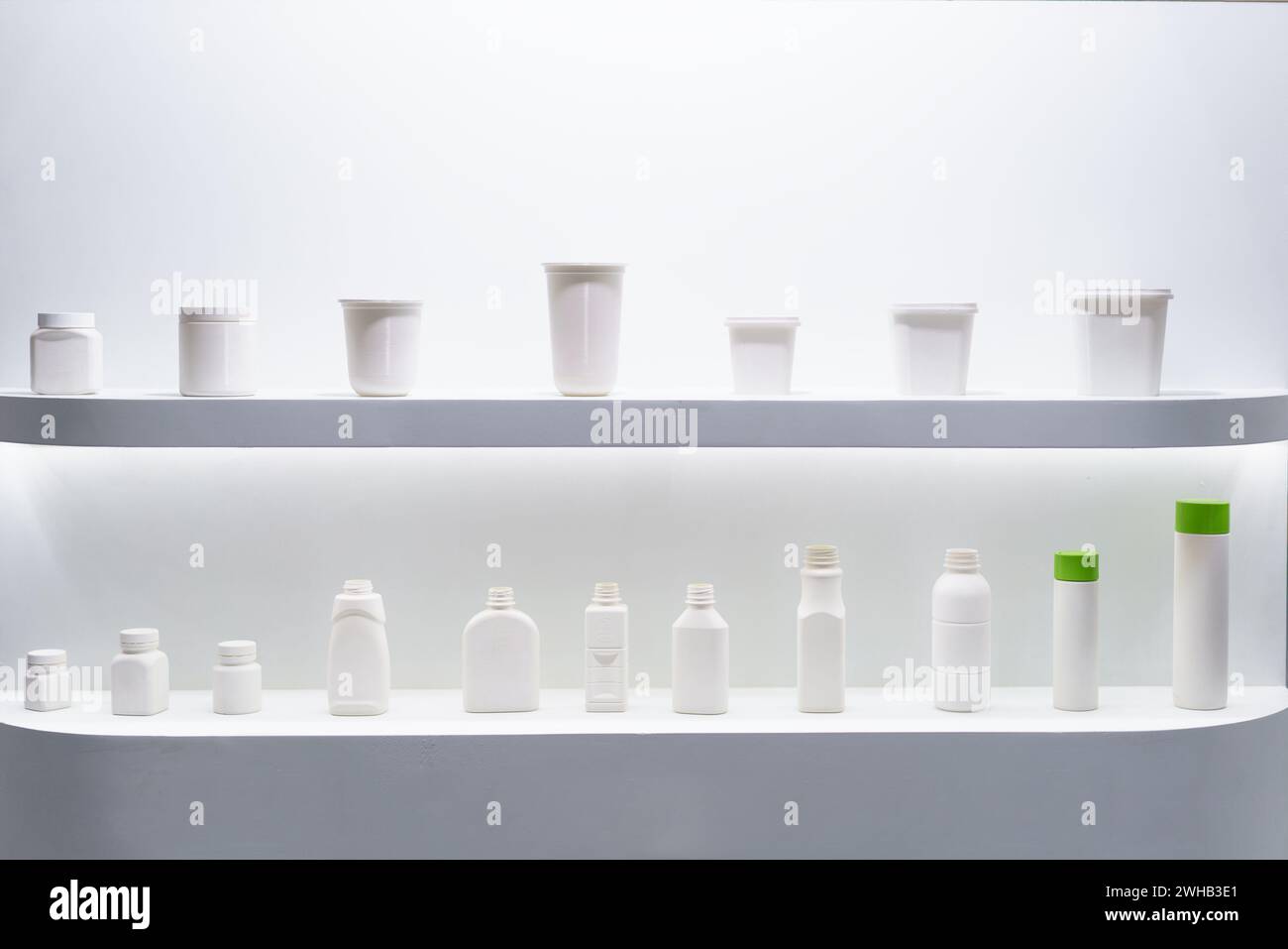 Un elegante espositore di vari contenitori per imballaggio bianchi sugli scaffali, caratterizzato da un design pulito e minimalista adatto per più prodotti Foto Stock