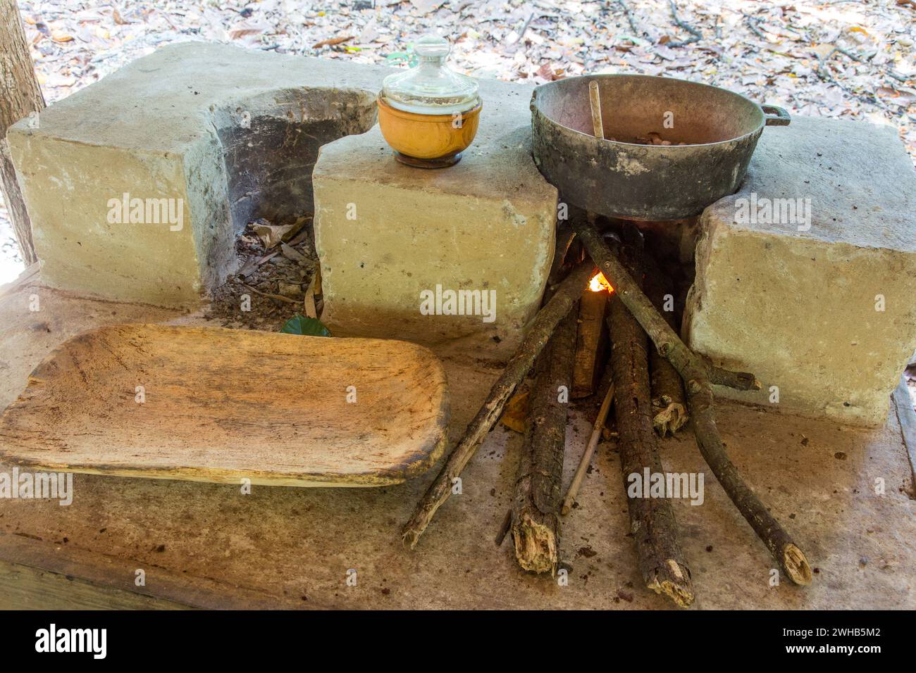 Una tradizionale stufa a legna e un vassoio di legno intagliato a mano per una dimostrazione in un tour della piantagione di cacao. Repubblica Dominicana. Foto Stock