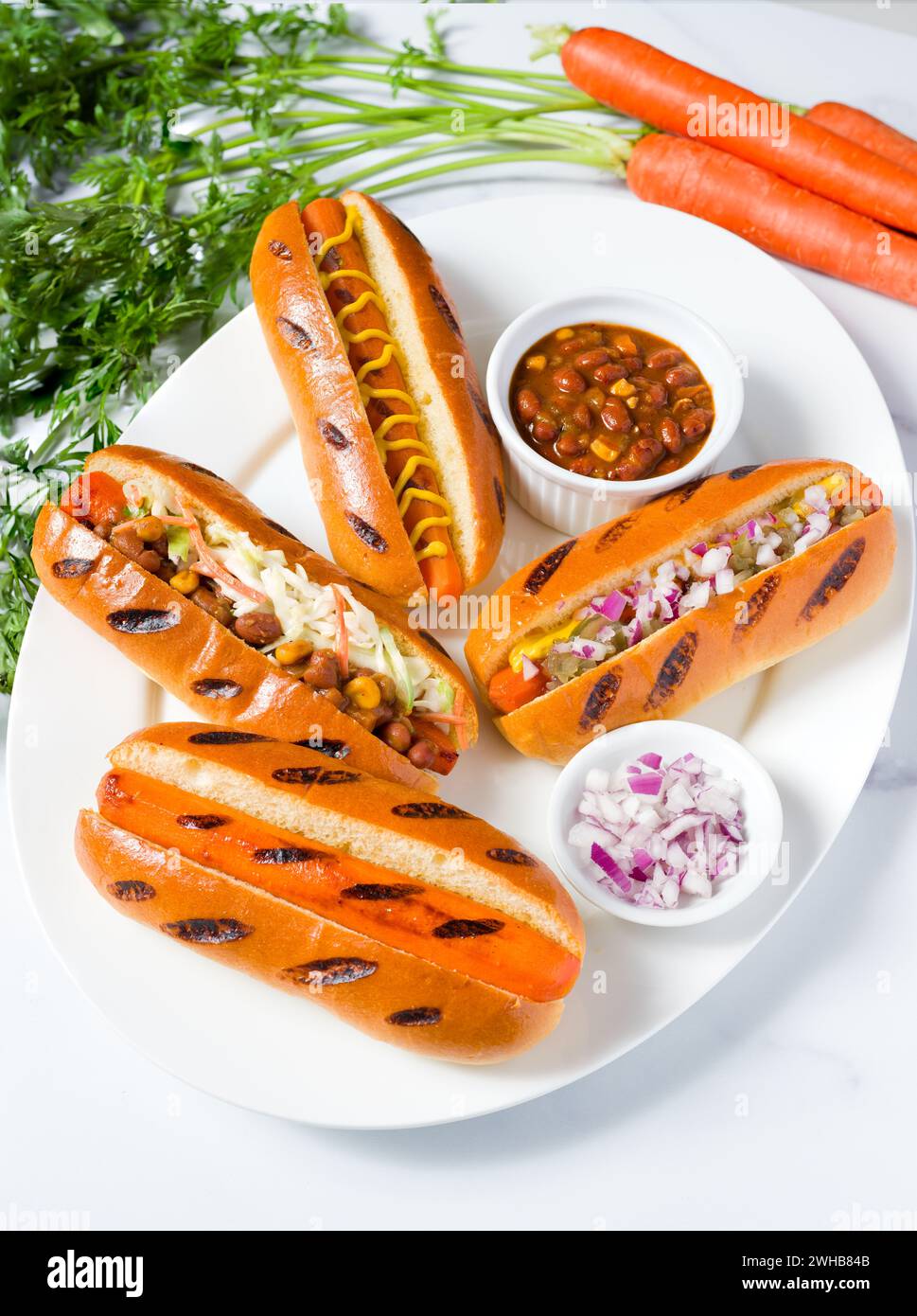 Dieta a base vegetale con cani di carota conditi con vari condimenti Foto Stock