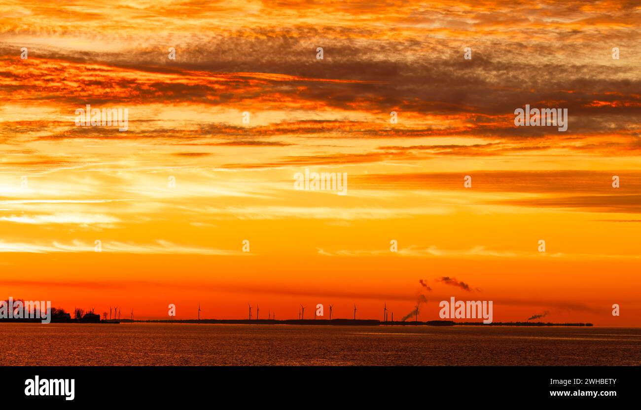 Turbine eoliche sotto il tramonto del cielo arancione in inverno sull'isola di Amherst, Ontario, Canada Foto Stock