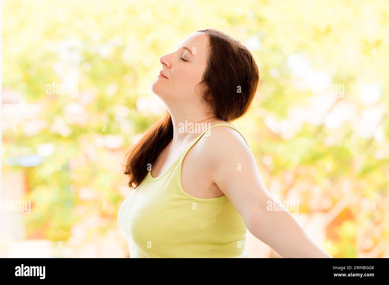 Ripresa di un ritratto di una donna felice che respira aria fresca all'esterno su uno sfondo naturale Foto Stock