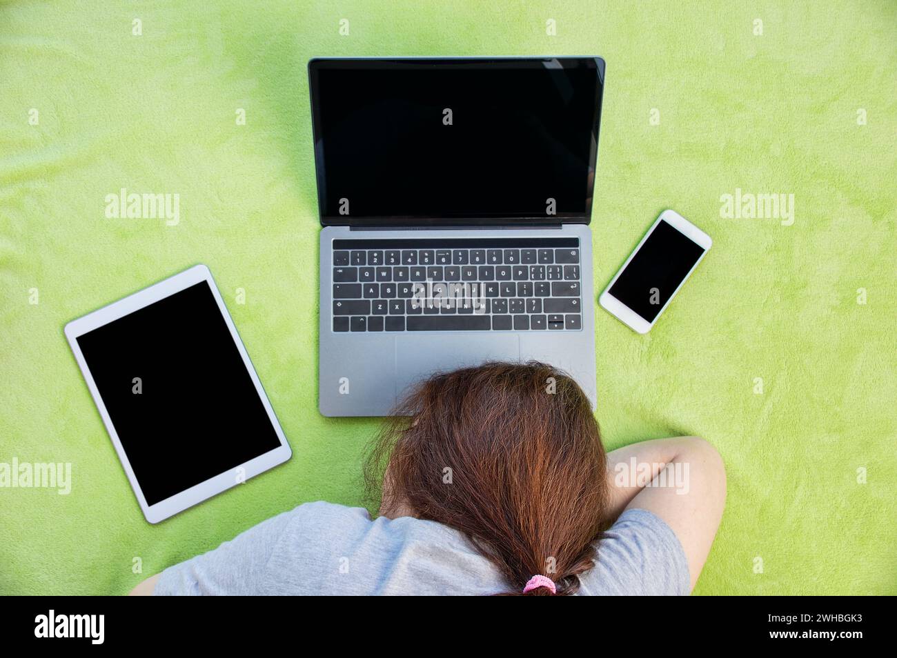 Donna d'affari stanca e sovraccarica che dorme su un notebook al lavoro a casa sua Foto Stock