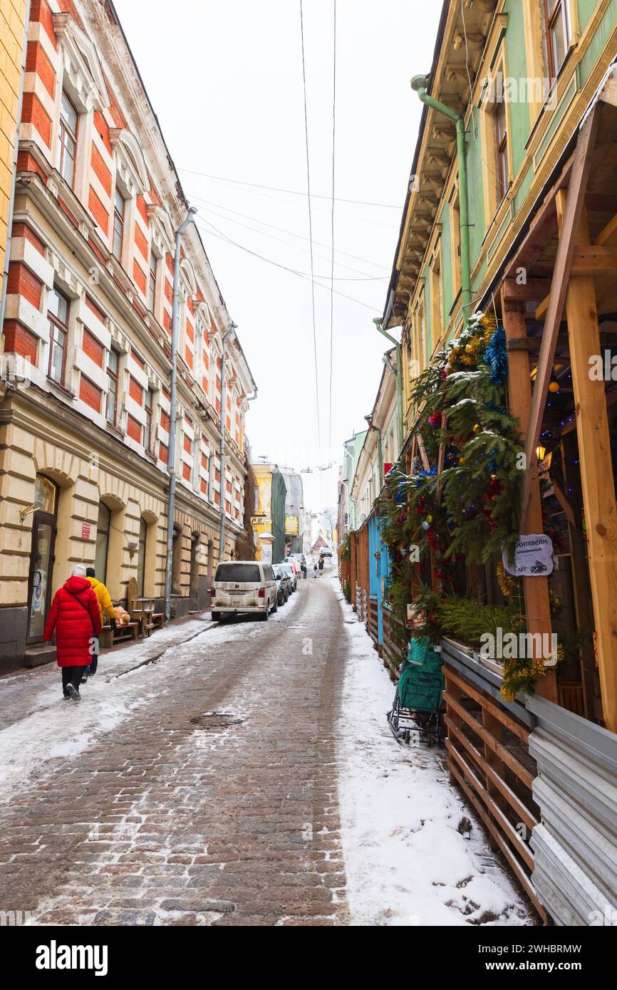 Vyborg, Russia - 18 febbraio 2023: Vista sulla strada prospettica con persone che camminano vicino a case residenziali in un giorno d'inverno. Città vecchia di Vyborg Foto Stock