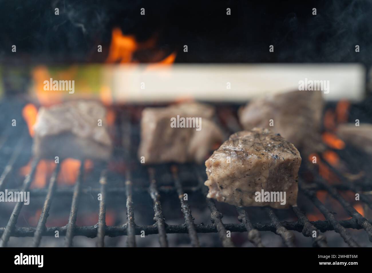 Pezzi di maiale sulla griglia. Un primo piano di carboni da barbecue e pezzi di maiale. Foto Stock