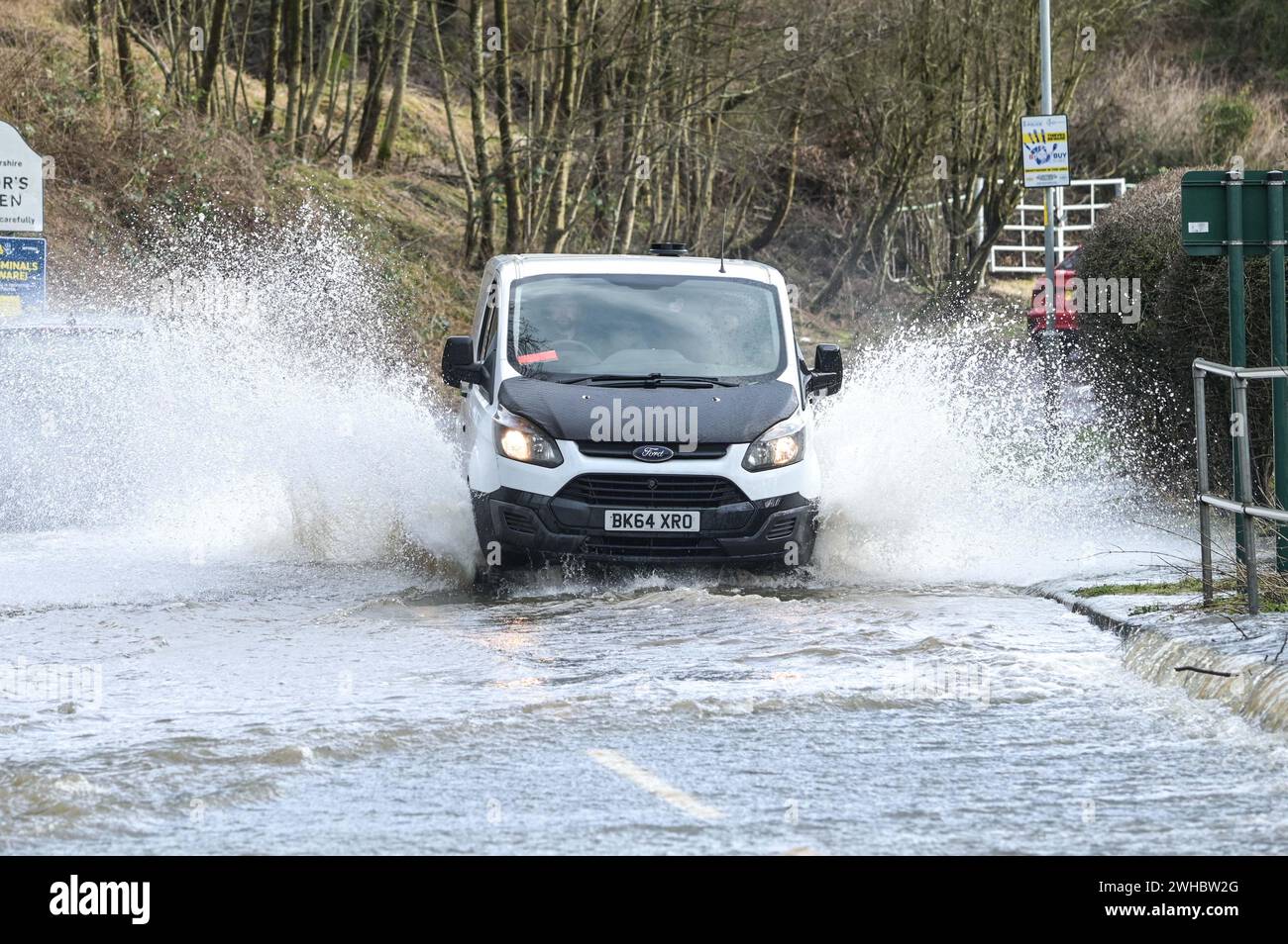 Major's Green, Bromsgrove, 9 febbraio 2024. Tre donne sono rimaste bloccate mentre cercavano di navigare nelle inondazioni nelle Midlands. Le donne alla fine trovarono la strada fuori da una banca su Peterbrook Road a Major's Green e lungo ringhiere metalliche come molti guidatori passavano, causando enormi onde di prua a causa delle forti precipitazioni oltre la luce e per tutto il giorno. Credito: Interrompi stampa Media/Alamy Live News Foto Stock