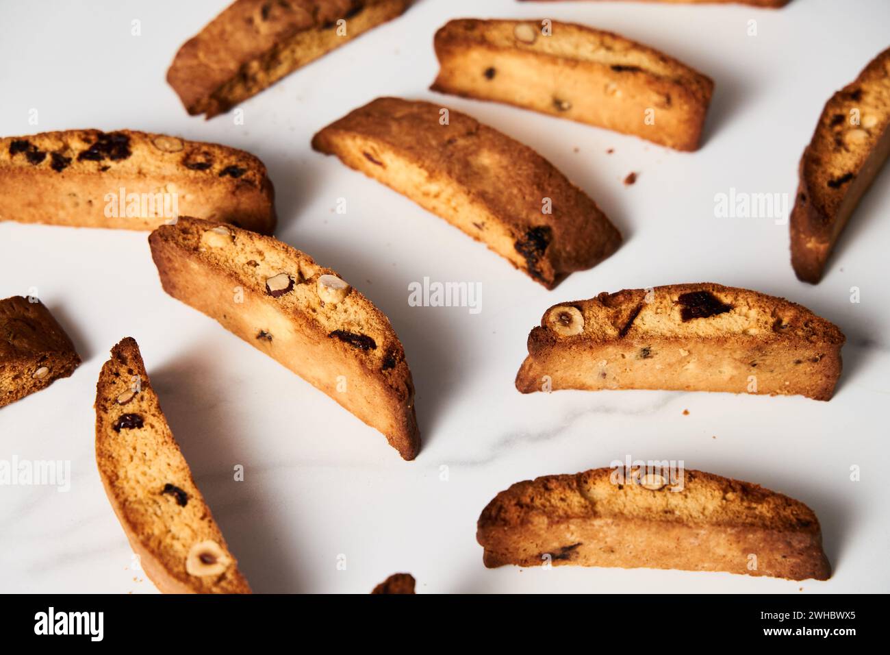 Primo piano di biscotti assortiti di mandorle, nocciole e mirtilli, disposti su sfondo bianco Foto Stock