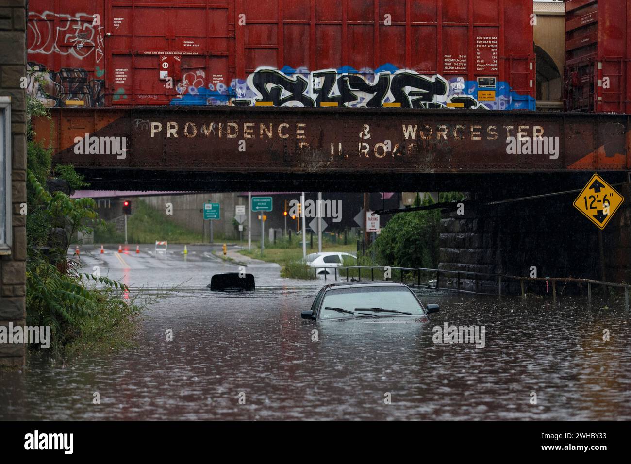 Le auto sono intrappolate in acque piene profonde sotto un ponte ferroviario a Worcester, Massachusetts, Stati Uniti. Foto Stock