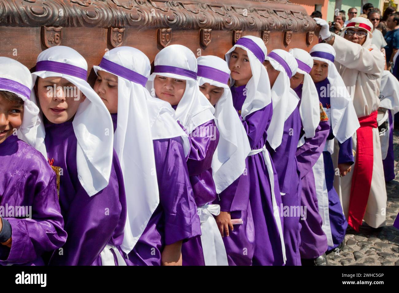 Antigua, Guatemala. Ragazzi adolescenti che portano un float in una processione religiosa durante la settimana Santa, la Semana Santa. Foto Stock