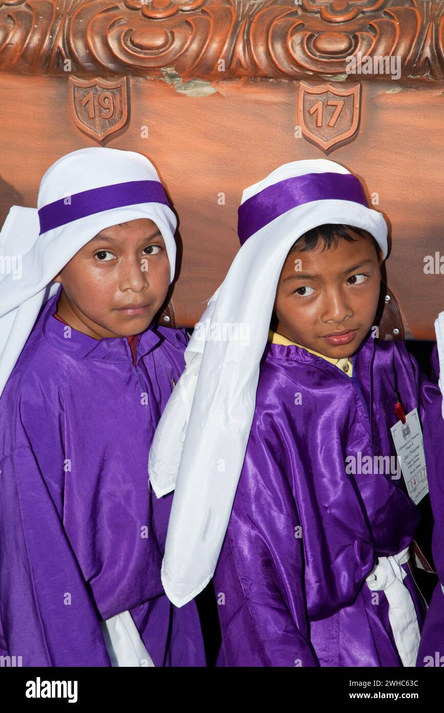Antigua, Guatemala. Giovani ragazzi che portano un galleggiante in una processione religiosa durante la settimana Santa, la Semana Santa. Foto Stock