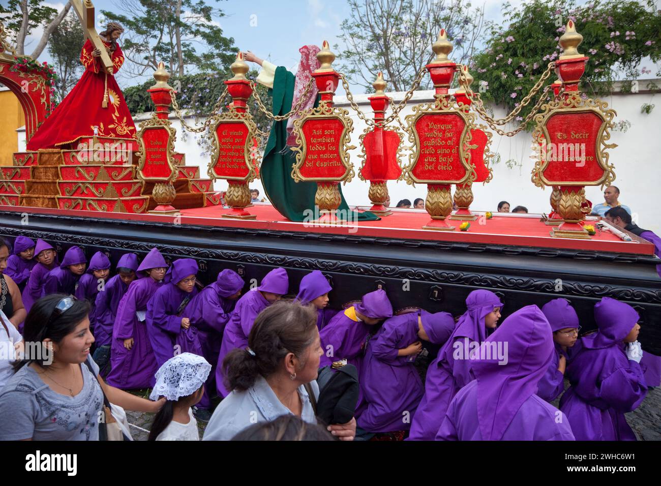 Antigua, Guatemala. Ragazzi adolescenti che portano un galleggiante (Anda) in una Processione religiosa durante la settimana Santa, la Semana Santa. Foto Stock