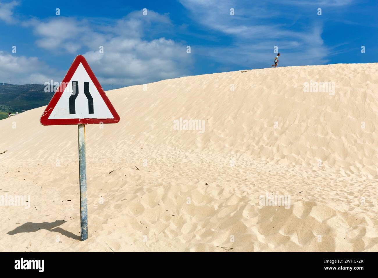 Duna in movimento con segnaletica stradale, corsia ristretta di attenzione, corsia ristretta, duna, costa vicino a Valdevaqueros, Tarifa, Costa de la Luz, Spagna Foto Stock