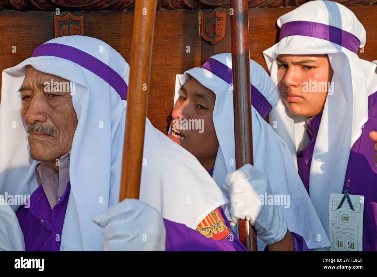 Antigua, Guatemala. Cucuruchos trasportando galleggiante (Anda) in una processione religiosa durante la settimana Santa, la Semana Santa. Foto Stock