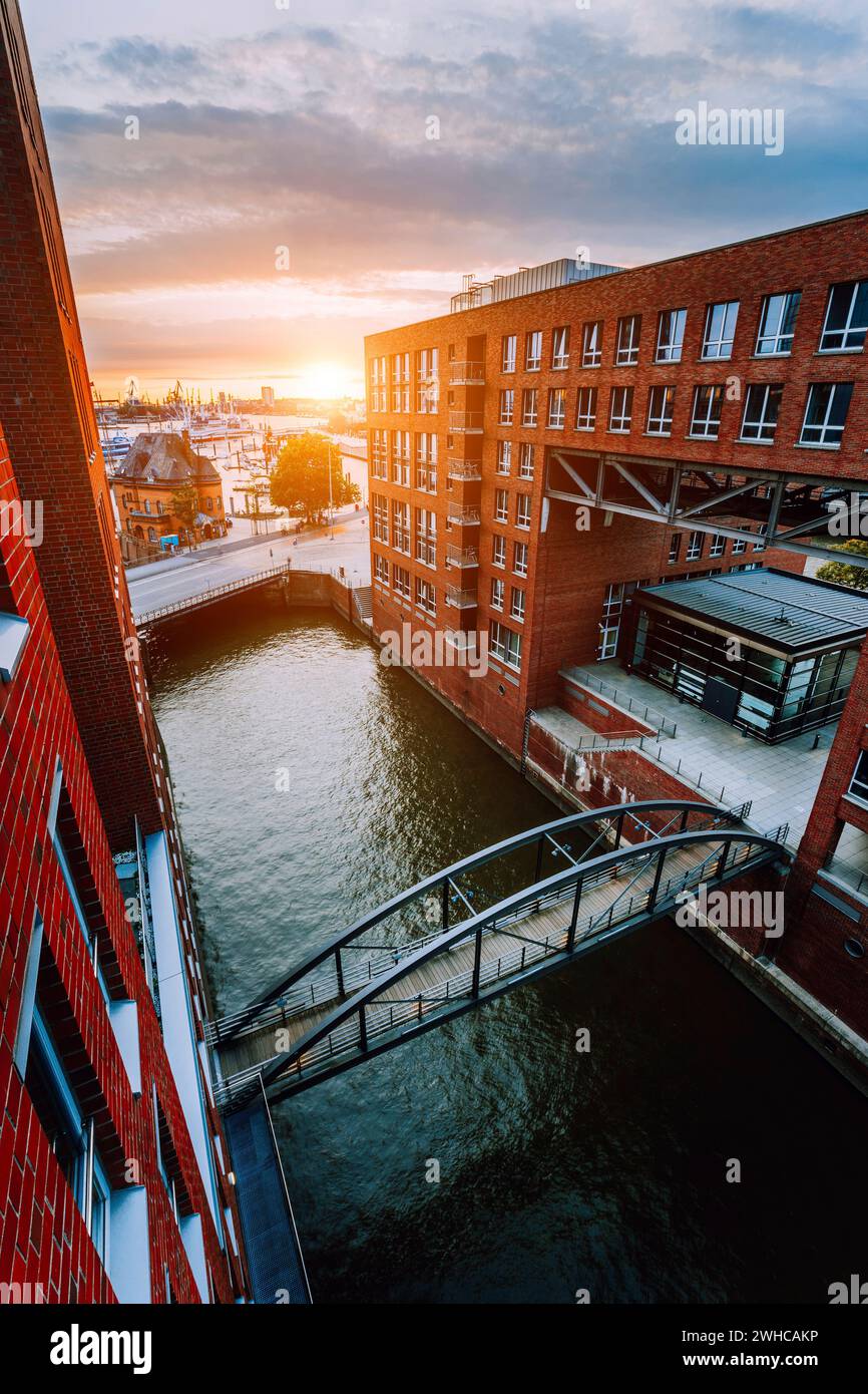 HafenCity. Ponte sul canale e gli edifici in mattoni rossi nel vecchio quartiere di magazzino Speicherstadt ad Amburgo in ore d'oro tramonto luce, Germania. Vista dall'alto. Foto Stock