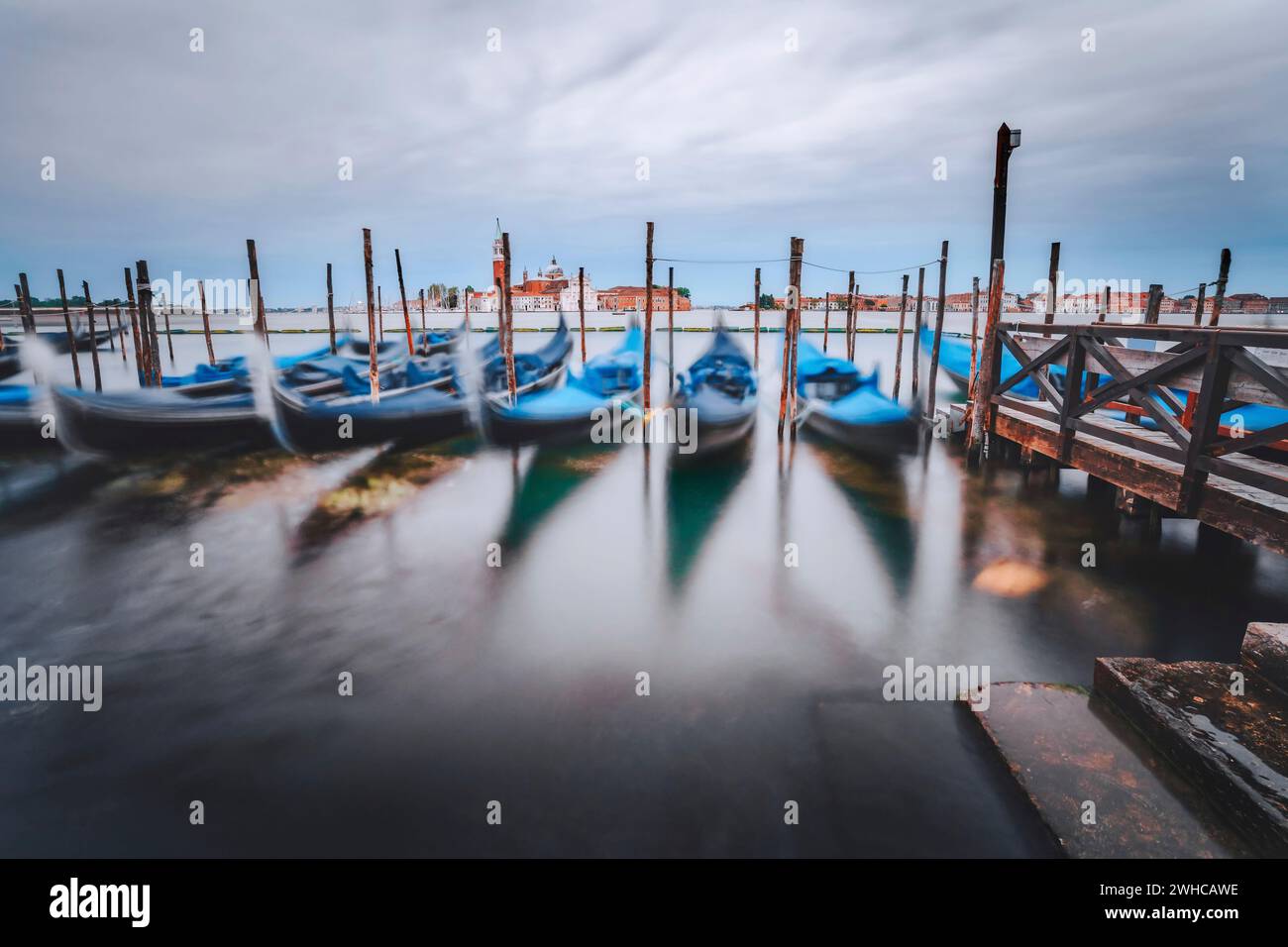 Serata di Moody con gondole che galleggiano nel Canal Grande con la chiesa di San Giorgio maggiore sullo sfondo. Foto Stock