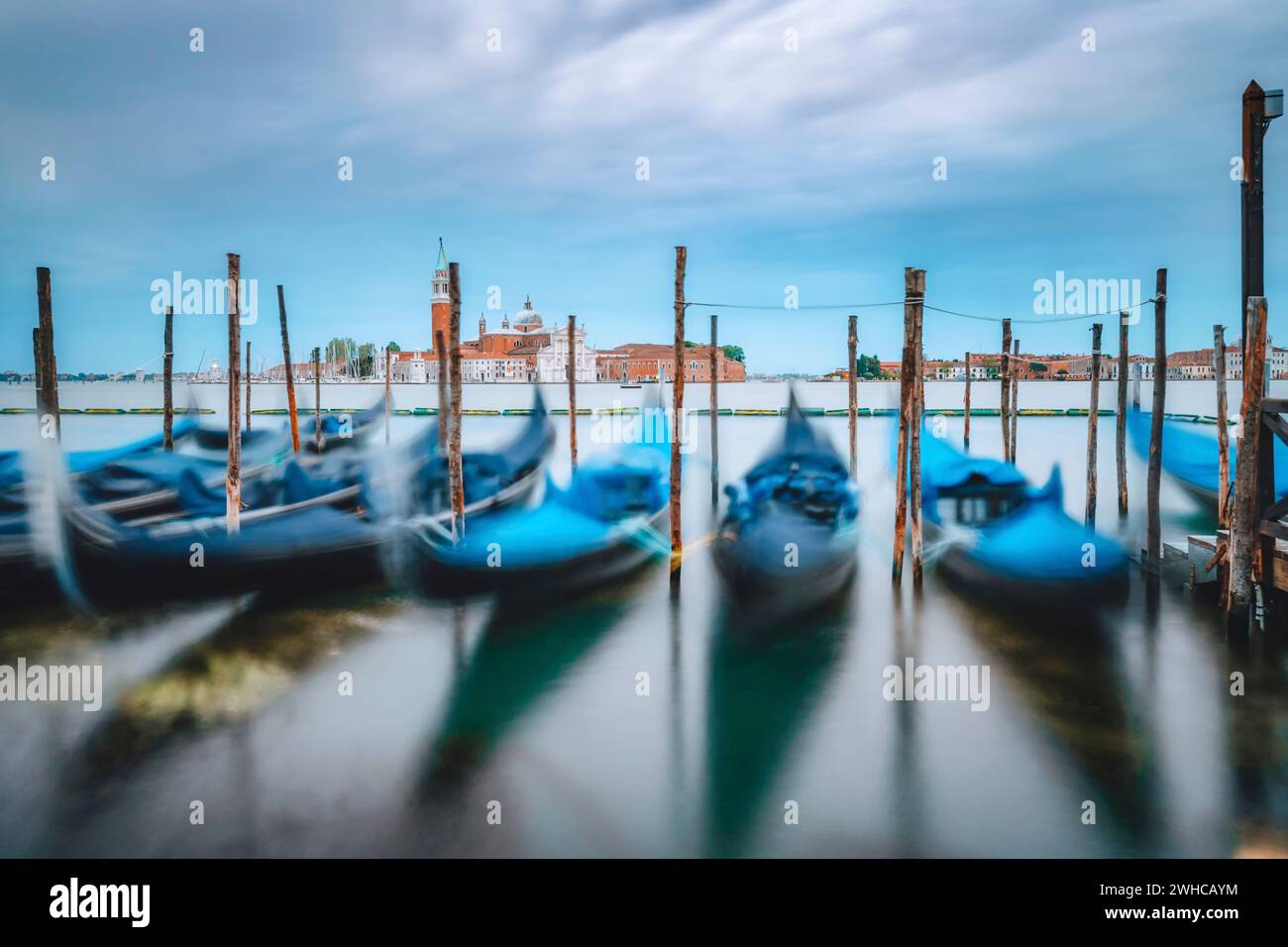 Movimento delle gondole che galleggiano nel Canal grande con messa a fuoco sulla chiesa di San Giorgio maggiore sullo sfondo. Foto Stock