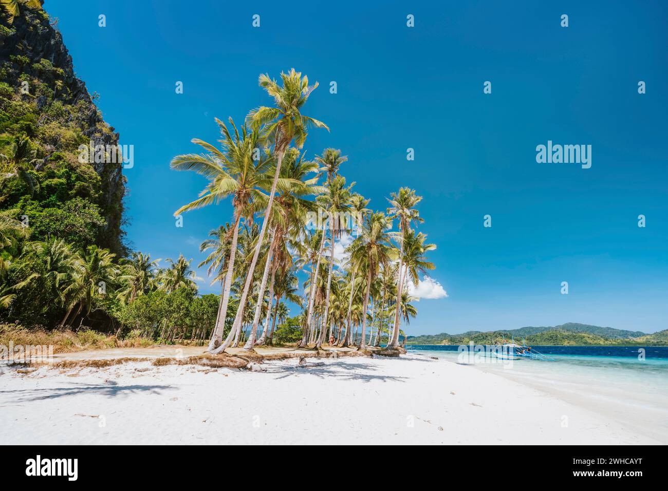 El Nido, Palawan, Filippine. Bellissima spiaggia di Ipil con palme da cocco, spiaggia sabbiosa e oceano blu. Foto Stock