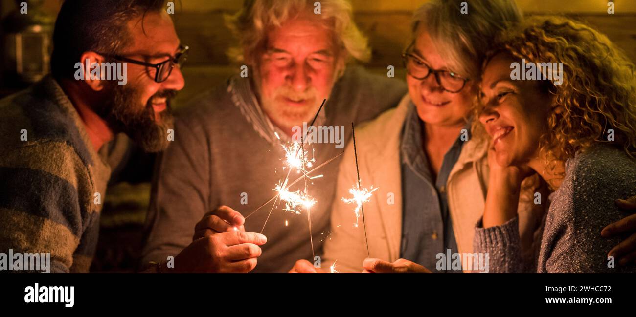 gruppo di persone che festeggia il nuovo anno 2021 dopo un duro 2020 - bye 2020 concetto - famiglia godere e divertirsi insieme con gli scintillatori a casa mangiare pizza a cena - christimas concetto Foto Stock