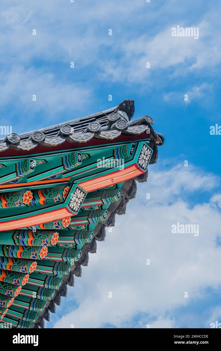 Colorata vigilia d'angolo del tempio orientale contro il cielo nuvoloso blu Foto Stock