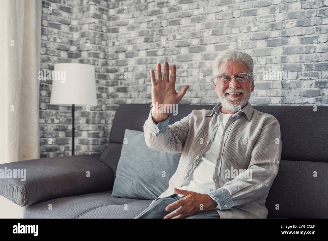 Ritratto di felice uomo maturo 80s seduto sul divano a casa guardare la macchina fotografica in posa relax nel fine settimana, sorridente positivo senior 70s nonno riposo sul divano a casa o casa di riposo, mostrare ottimismo Foto Stock
