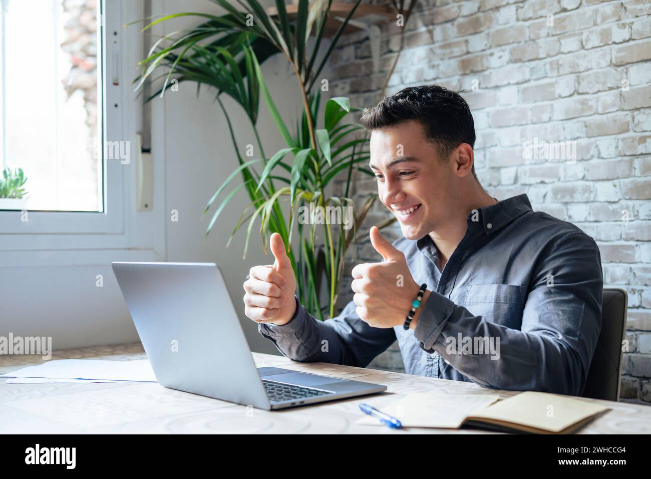 Uomo d'affari caucasico con un'esperienza millenaria concentrata con occhiali che indossano le cuffie con microfono, partecipa alle negoziazioni online con webcam utilizzando app per computer, concetto di comunicazione a distanza. Foto Stock