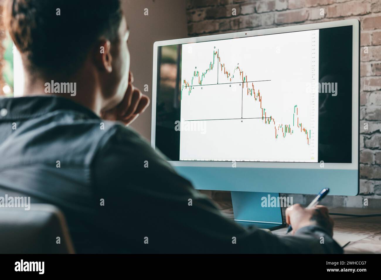 Uomo d'affari caucasico trader investitore analista che guarda ai grafici del mercato azionario finanziario tasso dinamico, crescita degli indici dei dati di trading utilizzando telefoni cellulari e laptop per l'analisi digitale delle criptovalute. Foto Stock