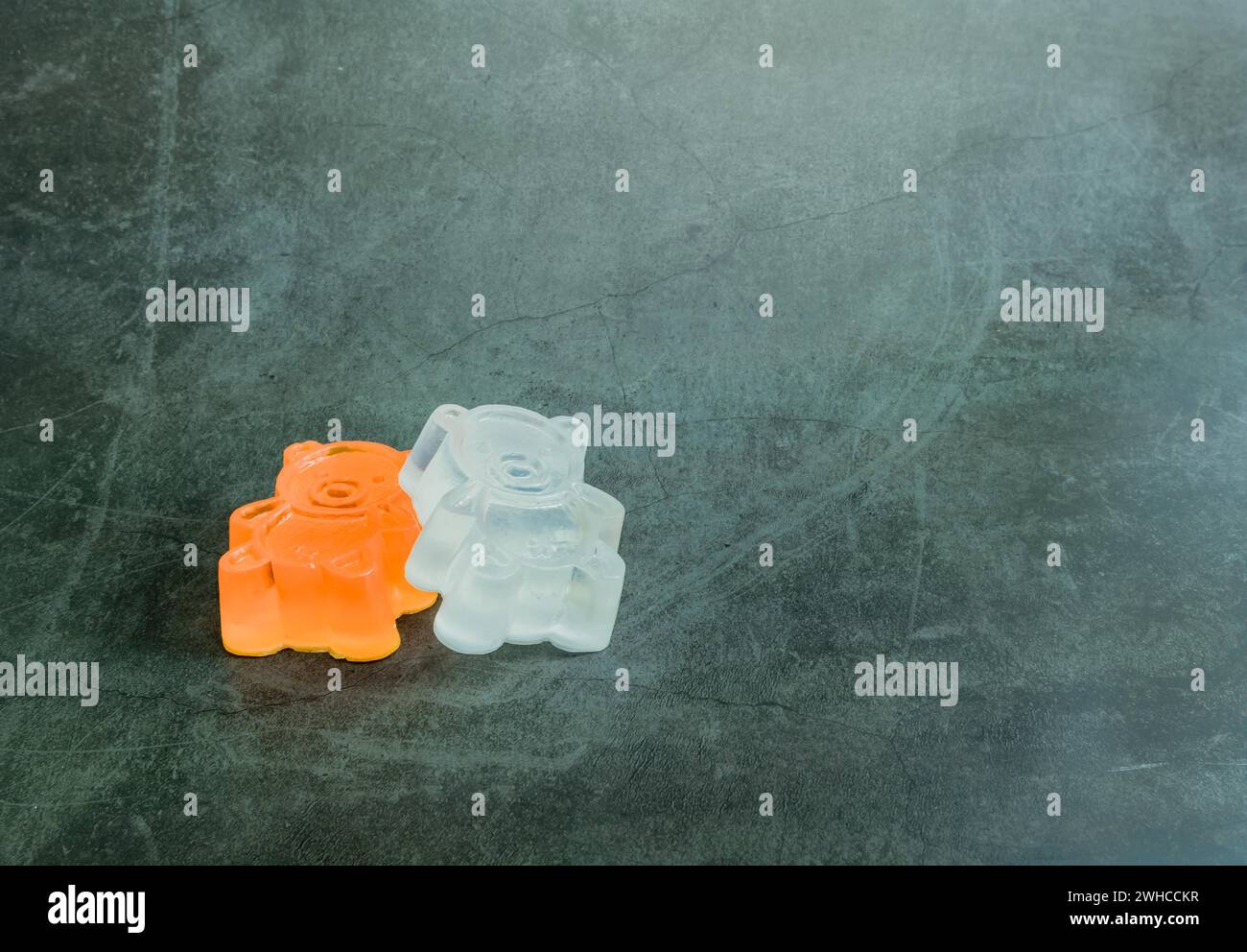Un sapone bianco fatto in casa, arancione, simile a un orso giocattolo su sfondo nero Foto Stock