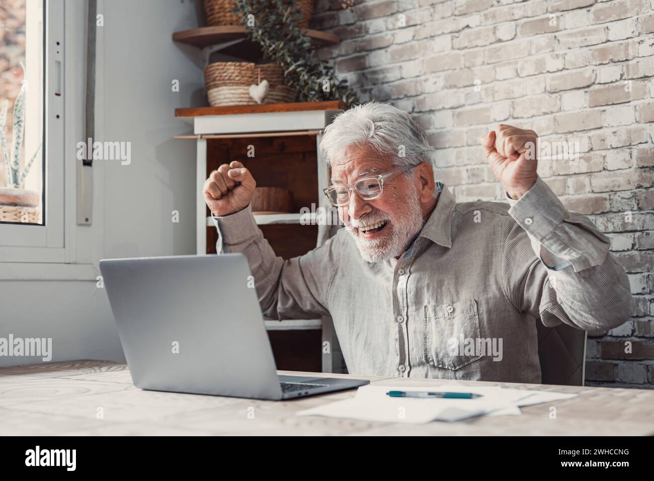 Felice, eccitato, vecchio anziano vincitore eccitato leggendo buone notizie guardando il notebook, felicissimo nonno anziano maturo che guarda la partita online celebrando goal Bid bet vincere grande risultato concetto di vittoria Foto Stock