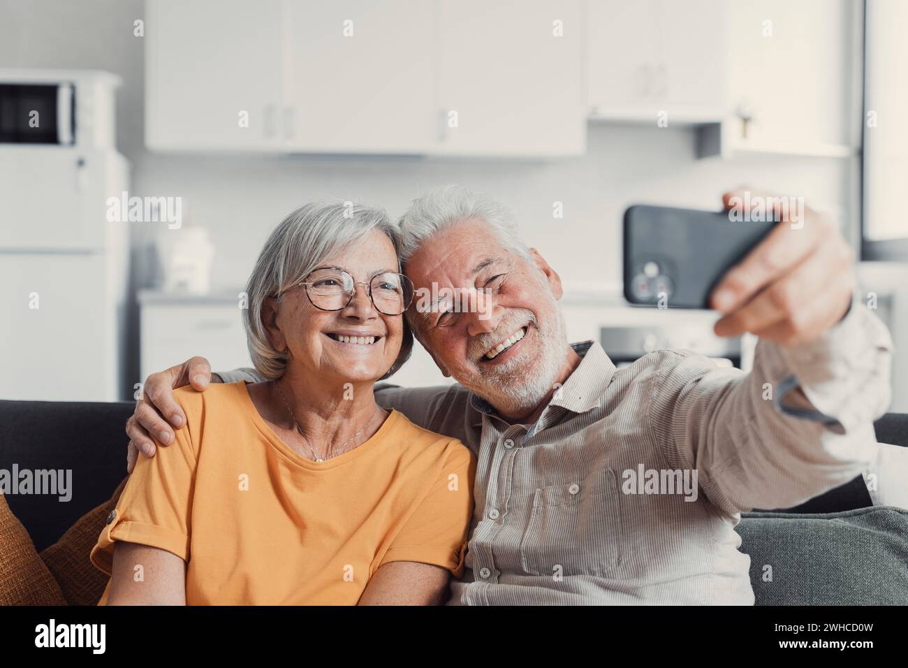 Una vecchia coppia felice che scatta selfie al cellulare, sposi anziani e maturi sorridenti, moglie di mezza età e marito in pensione che ridono tenendo il telefono, realizza un autoritratto sulla fotocamera dello smartphone, concentrandoti sul display del cellulare Foto Stock