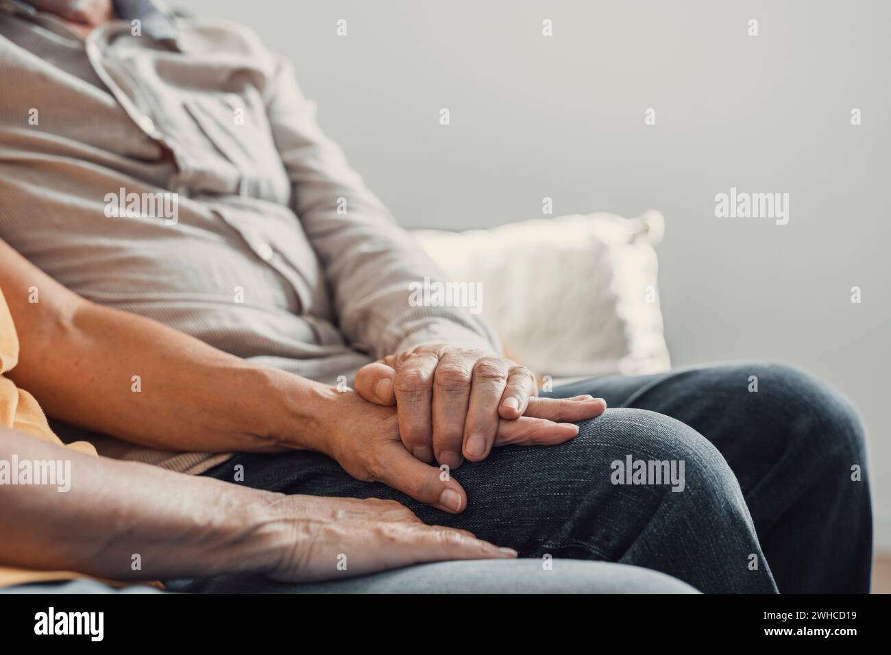 Primo piano donna affettuosa anziana che copre le mani rugose di marito maturo, mostrando amore e sostegno a casa. Una coppia di famiglie di mezza età premurosa Foto Stock
