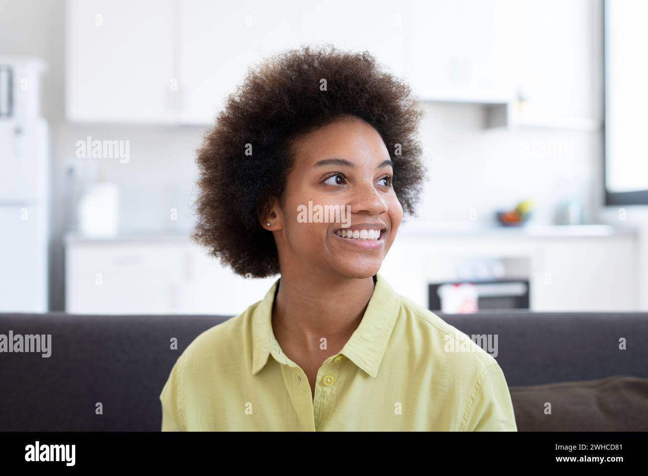 La testa ha scattato una giovane donna afro-americana che guarda in lontananza e riposa su un comodo divano. Ha ispirato la giovane Pretty Woman che sogna ad occhi aperti, visualizza il futuro, rievocando bei ricordi al chiuso. Foto Stock