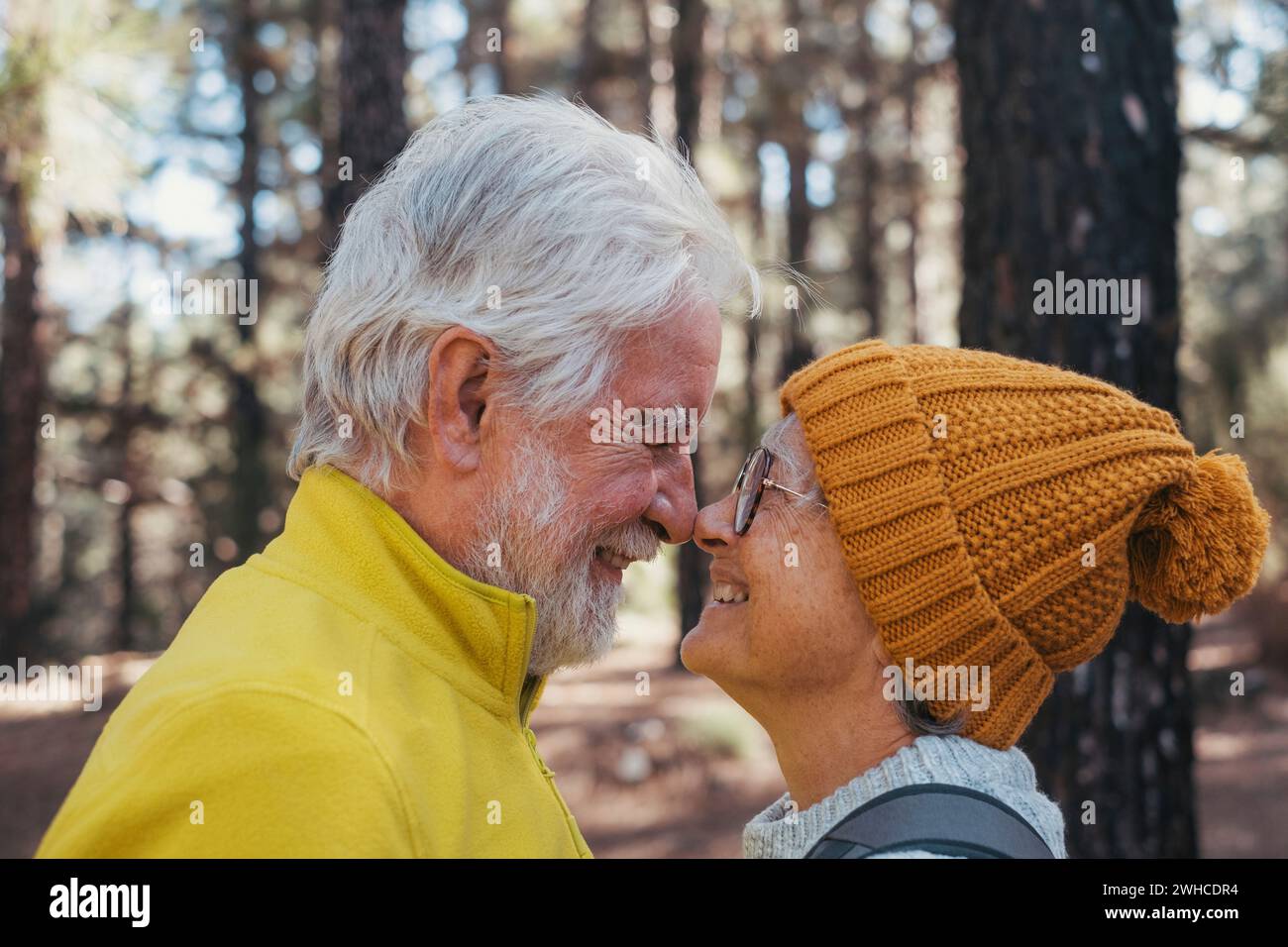 Ritratto, primo piano di persone anziane che sorridono e si divertono a guardarsi nella foresta di montagna. Una bella coppia di anziani maturi innamorati che si sentono felici e si prendono cura di loro. Foto Stock