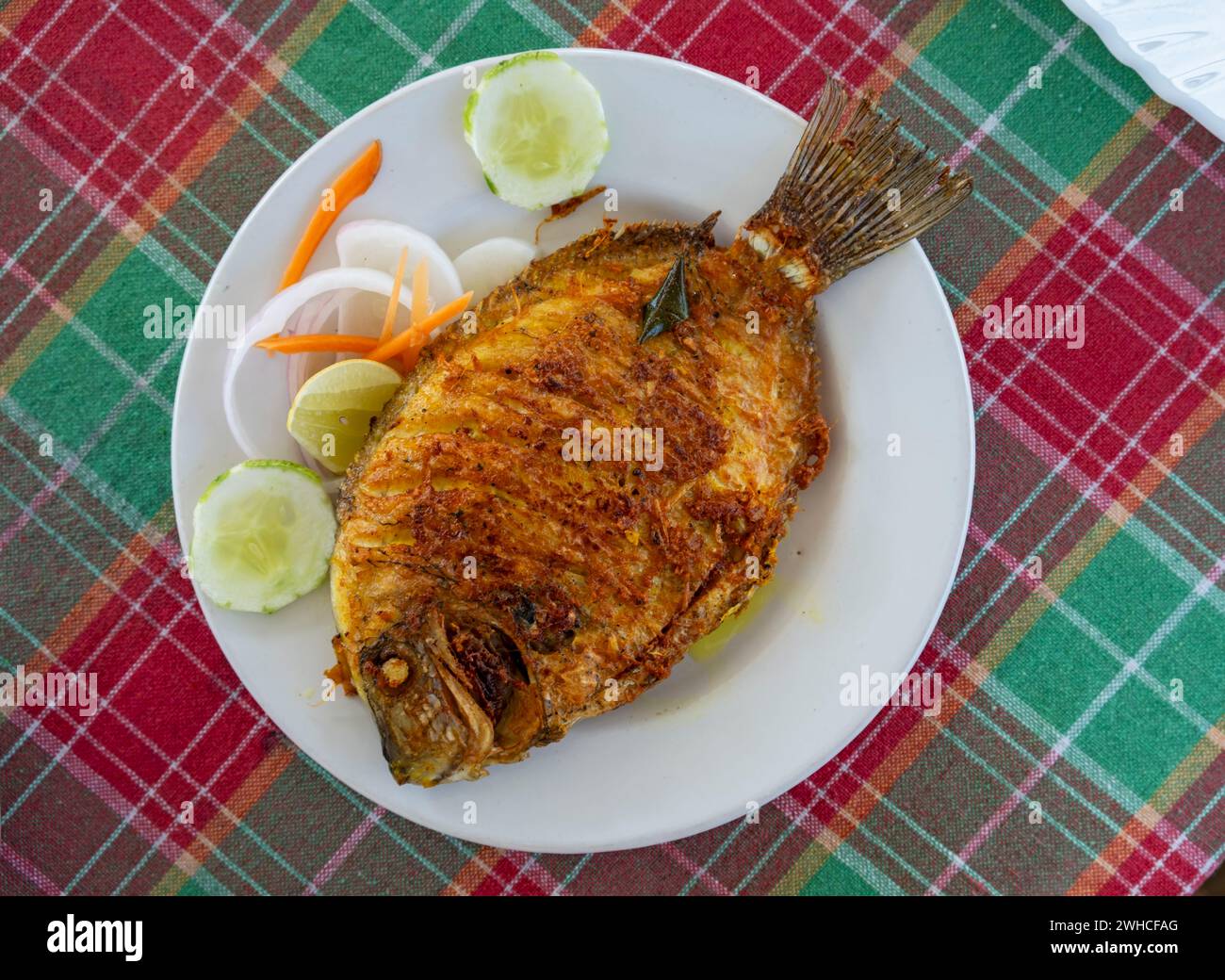 Un tradizionale piatto di pesce fritto del Kerala, il Pearl Spot (Etroplus suratensis), localmente conosciuto come "Karimeen", servito su un piatto, India Foto Stock