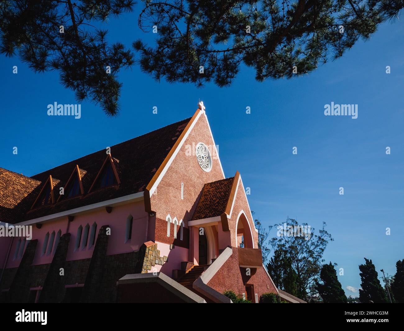 Domaine De Marie Church Diocesi sullo sfondo blu del cielo, nascosta dietro i rami di pini nelle giornate di sole, situata a da Lat, provincia di Lam Dong, Vietnam. Foto Stock