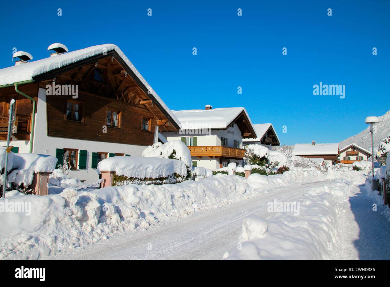 Passeggiata invernale a Mittenwald, case coperte di neve nel Schöttelkarstraße, sgombero della neve, valle dell'Isar, Europa, Germania, Baviera, alta Baviera, Werdenfels, inverno Foto Stock