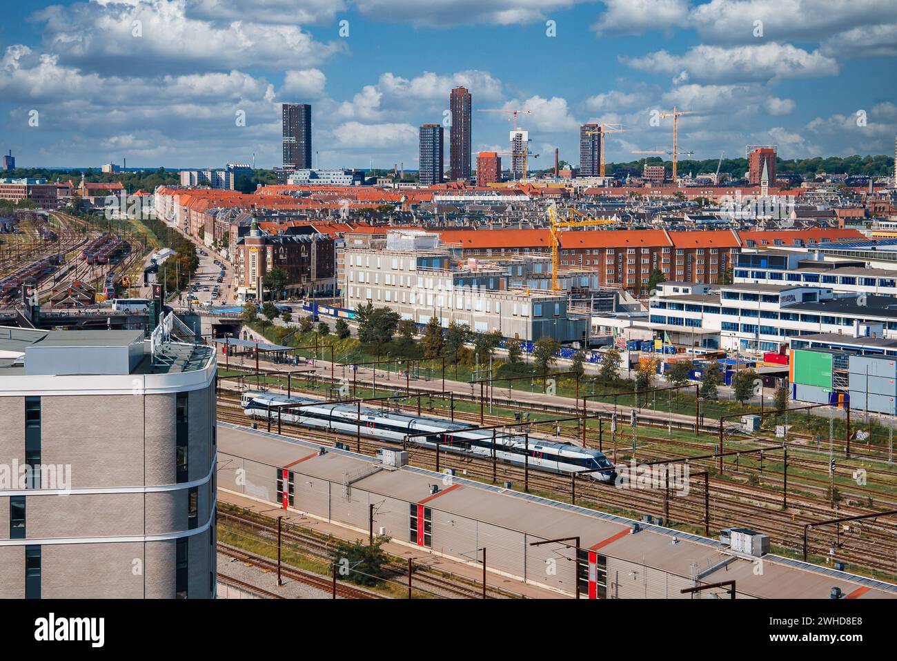 Paesaggio urbano diurno con un treno, situato a Copenhagen. Foto Stock