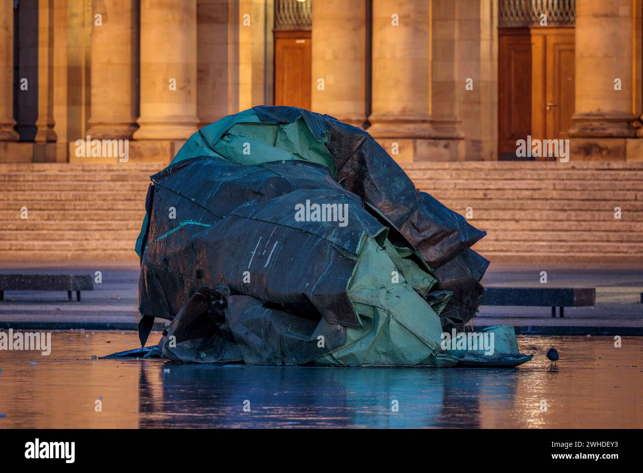 Germania, Baden-Württemberg, Stoccarda, ripresa notturna del tetto distrutto del Teatro dell'Opera di Stoccarda come memoriale nel lago ghiacciato di Eckensee, teatro dell'opera sullo sfondo Foto Stock