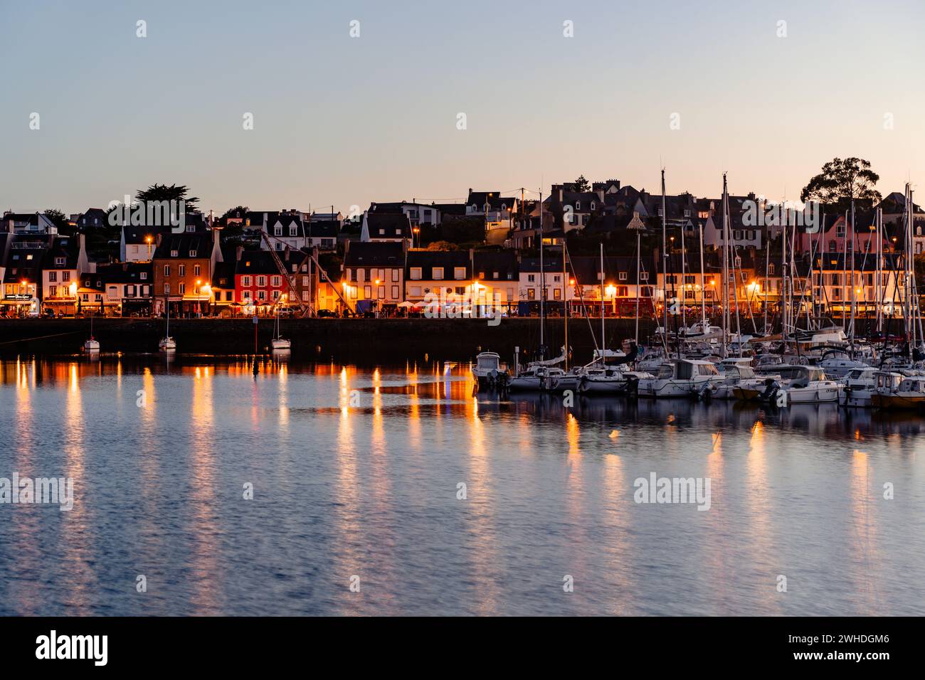 Tramonto al porto di Camaret-sur-Mer, Bretagna, ora d'oro, atmosfera di vacanza, vista della città illuminata Foto Stock